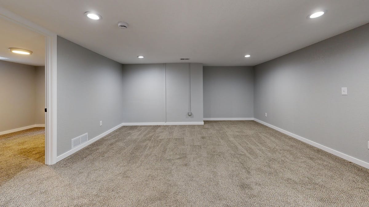 Empty basement room with bare concrete slab prone to moisture issues before epoxy